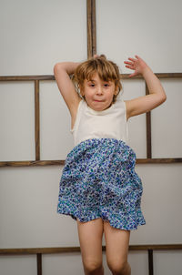 Portrait of girl standing against wall