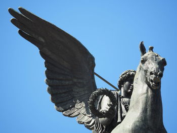 Low angle view of statue against clear blue sky