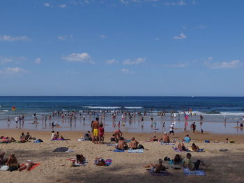 People at beach against sky