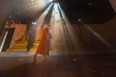 Low angle view of boy wearing traditional clothing walking in buddhist temple