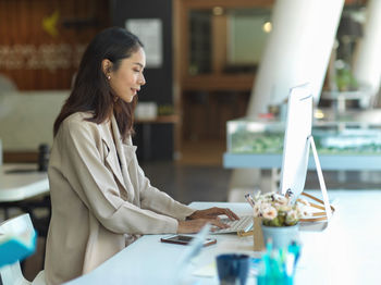 Side view of young businesswoman working at office