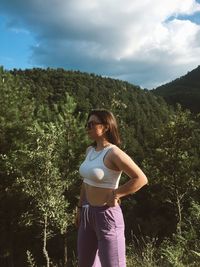 Woman standing by tree against sky