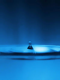 Close-up of water drop against blue background