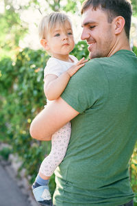 Father and son holding baby