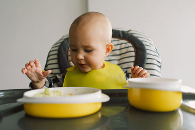 Little child with solid nutrition. baby girl eating food and mix vegetable plate