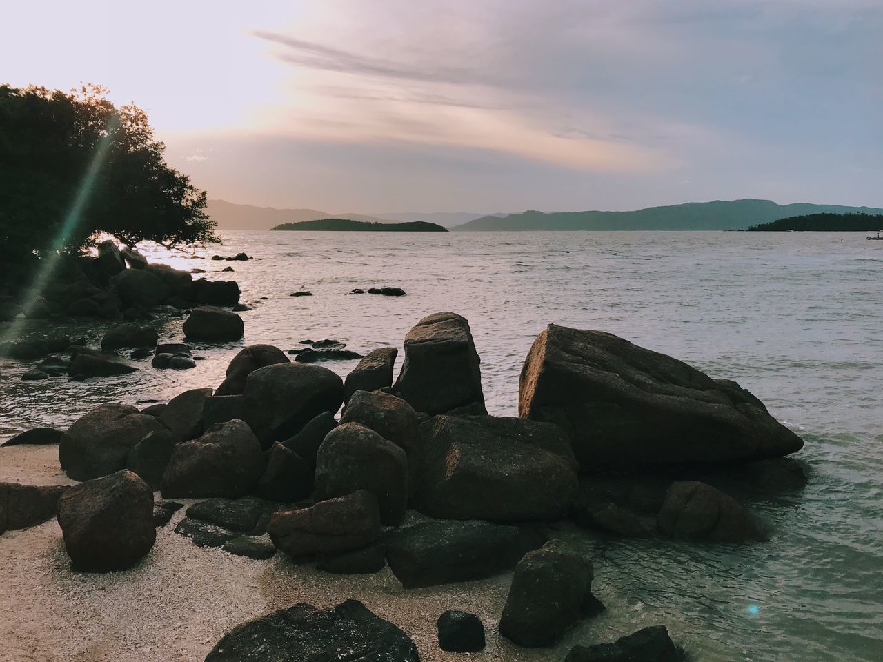 STACK OF STONES ON BEACH AGAINST SKY