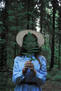 Rear view of woman standing in forest
