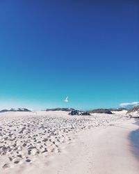 Scenic view of snow covered field against clear blue sky