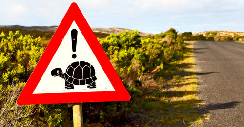 Close-up of road sign against sky