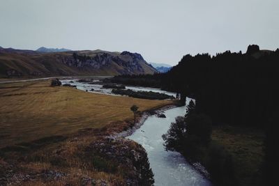 Scenic view of river amidst mountains against clear sky
