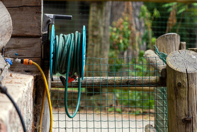 Close-up of metal fence against blue wall