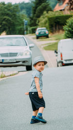 Portrait of young woman standing on road