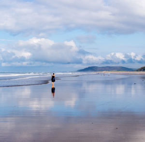 A woman walking on the beach in ynyslas beach near aberystwyth, wales