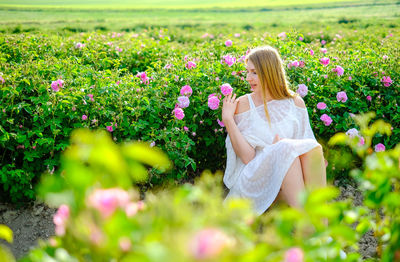 Rear view of woman with pink flowering plants