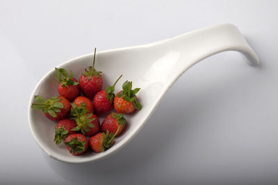 Close-up of strawberries in spoon on white background