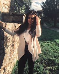 Portrait of smiling young woman standing on tree