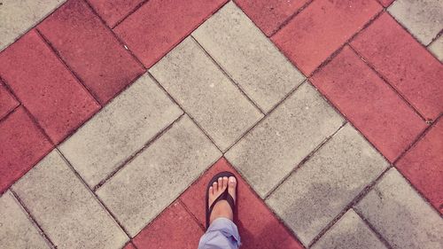 Low section of man standing on tiled floor