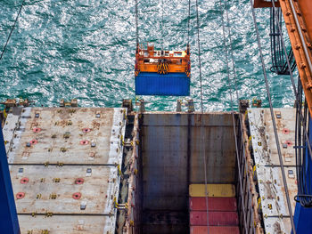 Containers are discharging from vessel by port crane at port of thailand,