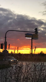 Silhouette of city against dramatic sky during sunset