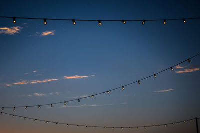 Low angle view of illuminated lights against sky at night