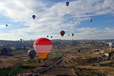 Hot air balloons flying over landscape