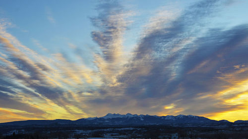 Scenic view of snowcapped mountains against sky during sunset