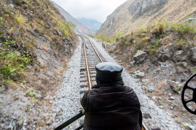 Rear view of man standing on mountain road