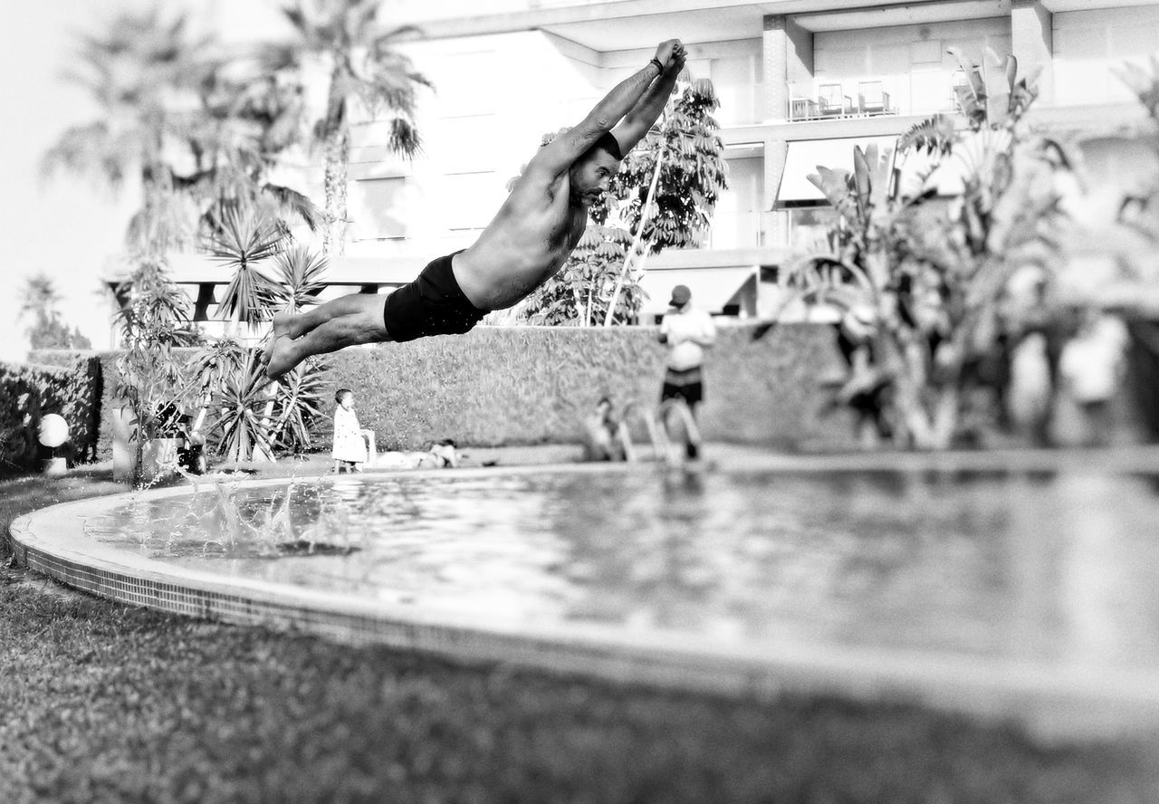 black and white, monochrome photography, monochrome, one person, lifestyles, adult, water, day, nature, sports, selective focus, city, men, leisure activity, motion, jumping, plant, architecture, outdoors, vitality, white, women