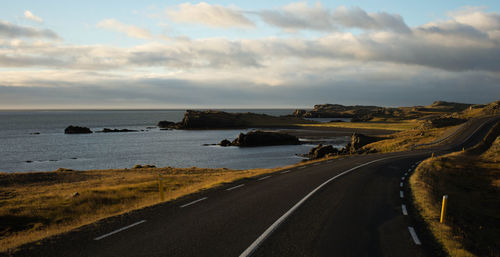 Road by sea against sky