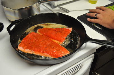 Close-up of person preparing food in pan