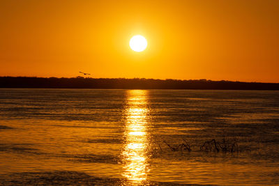 Scenic view of sea against romantic sky at sunset