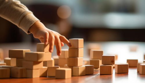 Cropped hand of man holding toy blocks