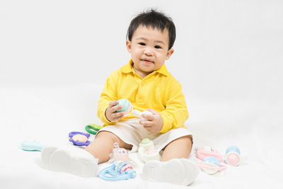 High angle view of cute baby boy playing with toys against white background