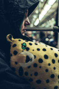 Close-up of thoughtful woman wearing hood sitting in vehicle