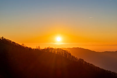 Scenic view of silhouette mountains against sky during sunset