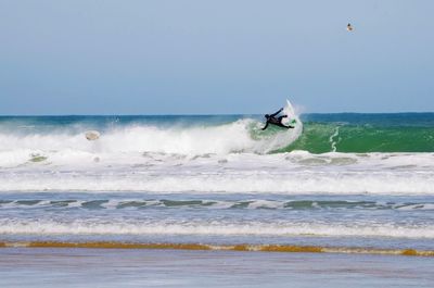 Man surfing on sea against sky