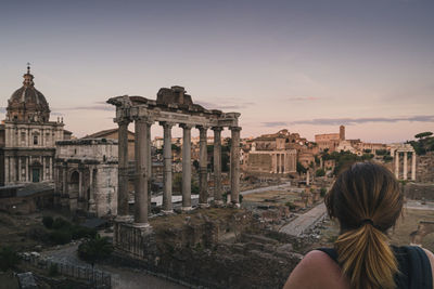 Rear view of woman looking at old building in city