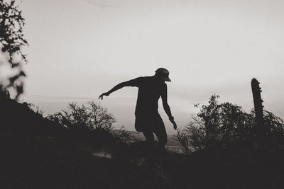 Low angle view of man standing on field against sky