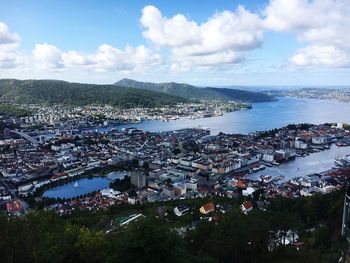 High angle view of city by sea against sky