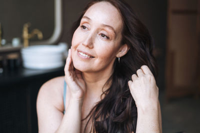 Close up portrait of smiling adult brunette woman in underwear in bathroom at home