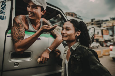 Young man smiling while sitting in car