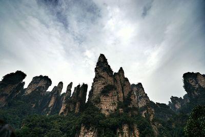 Low angle view of mountains at wulingyuan against cloudy sky