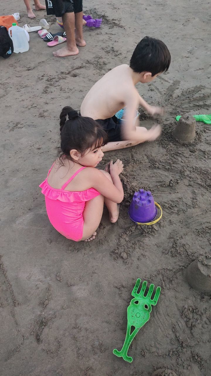 high angle view, leisure activity, child, women, childhood, full length, adventure, togetherness, sports, female, lifestyles, adult, land, friendship, men, rock climbing, group of people, climbing, nature, person, sand, clothing, beach, day, outdoors, activity, bonding, young adult, pink, directly above, lying down, family, enjoyment, small group of people, relaxation