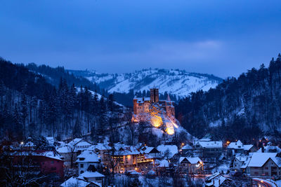 Snow covered trees and buildings against sky