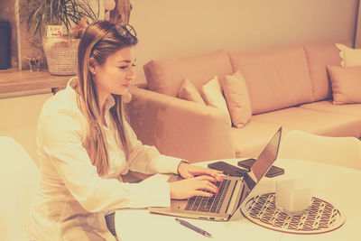 Young woman using laptop at home