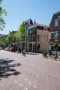 Street by buildings against sky