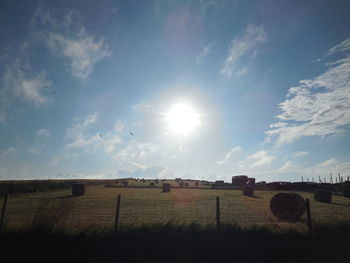 Hay bales on field against sky