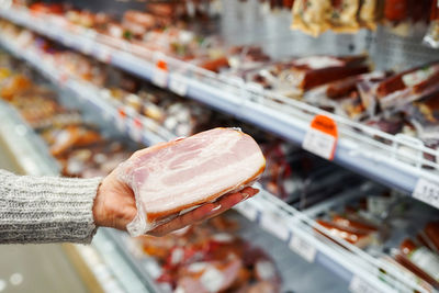 Buyer hand with pork meat packages at the grocery store