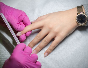 High angle view of woman hand on pink finger