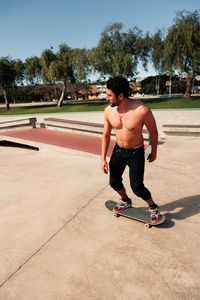 Man riding skateboard in urban street skatepark. casual guy wearing shorts and t-shirt.